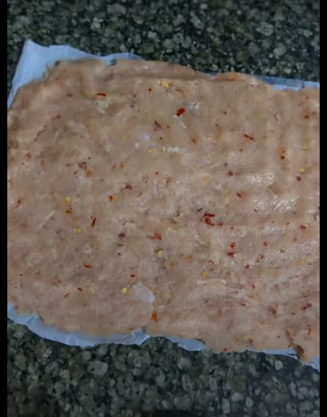 Spreading Chicken Mince for Loaf Preparation Chicken mince spread on tray